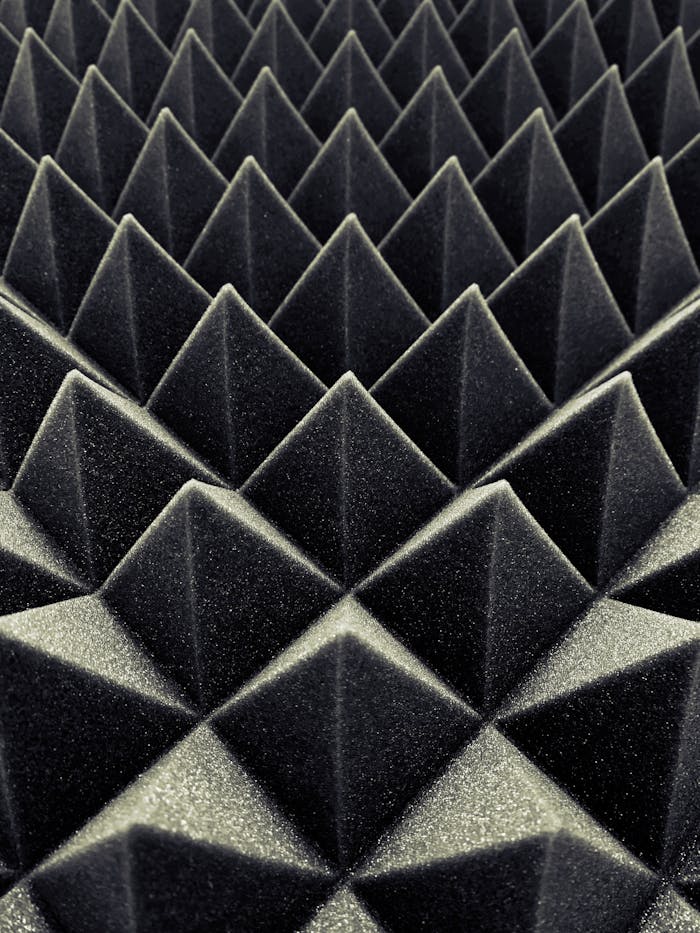 hero-img-02 Textured black acoustic foam panels create a striking geometric pattern.