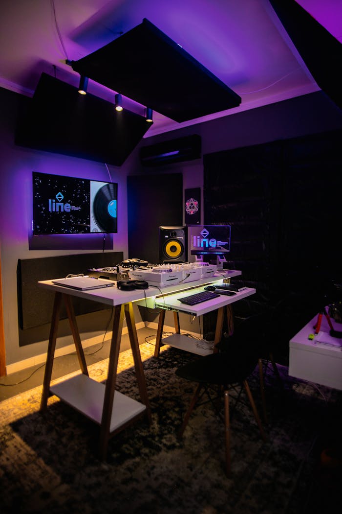 why-choose-us A stylish recording studio with neon lights, computer monitors, and audio equipment for music production.